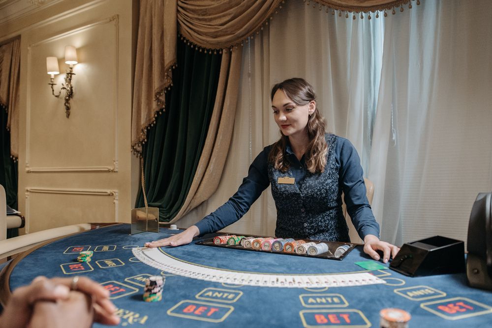 Dealer kasino membagikan kartu dan chip di meja permainan