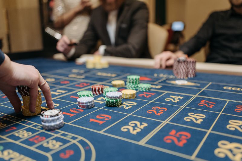 Tangan pemain menempatkan chip di meja taruhan
