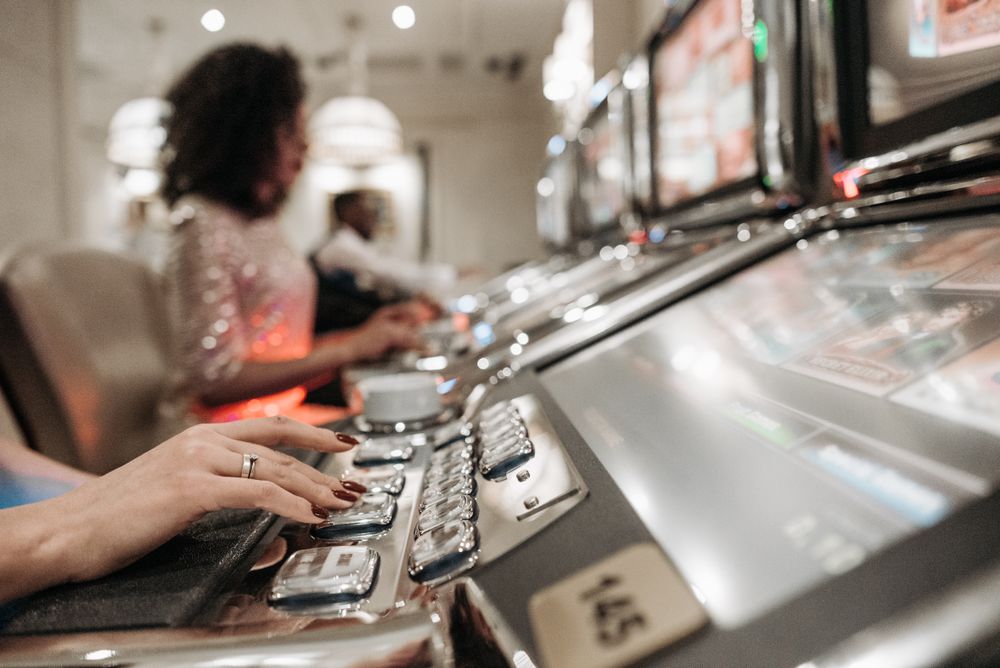 Deretan mesin slot berwarna-warni di lantai kasino